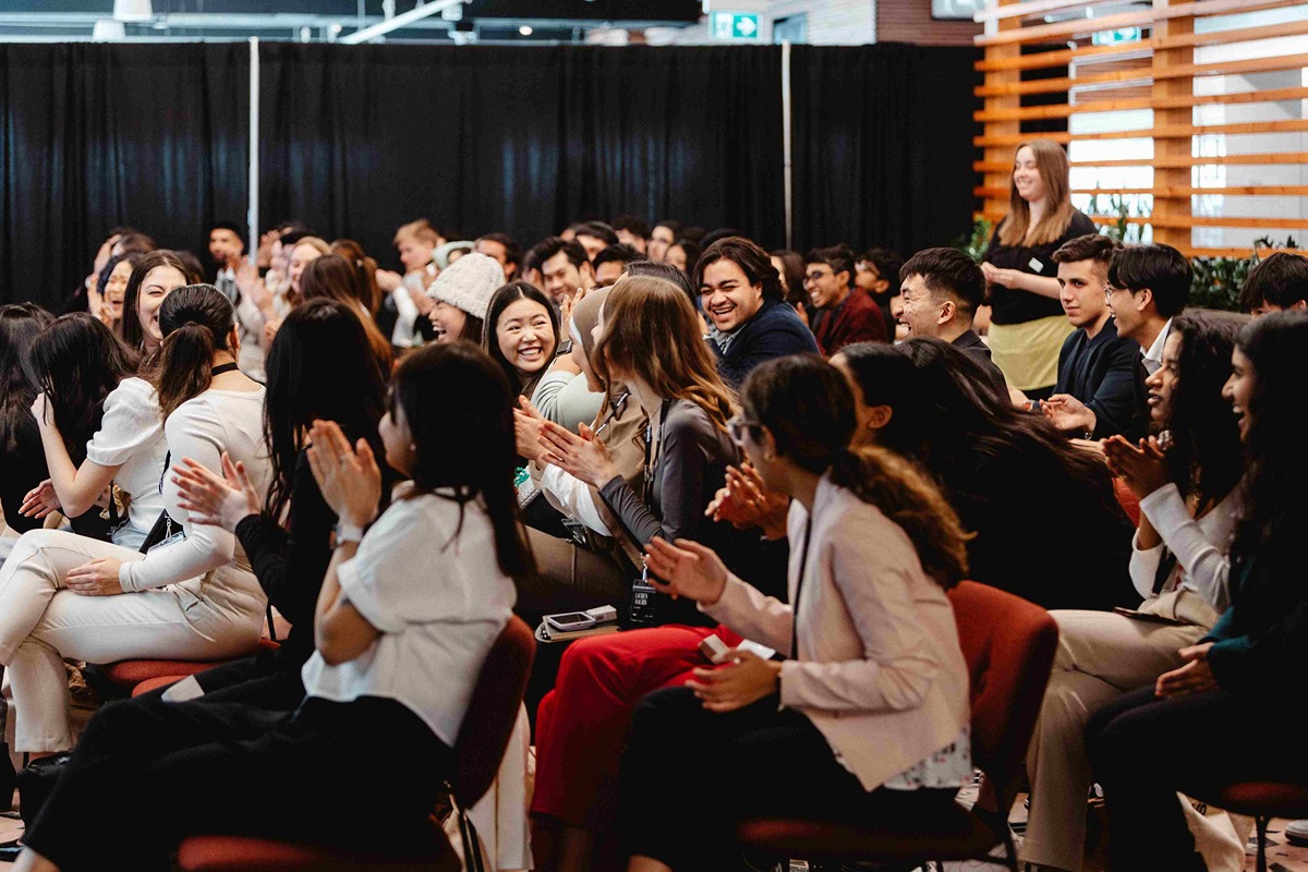 Crowd of students laughing together at a conference event
